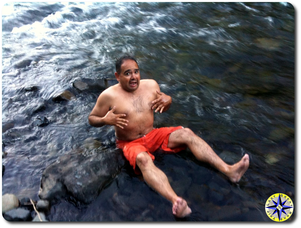 man sitting in cold river water