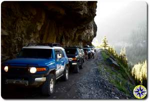 fj cruisers under rock ledge