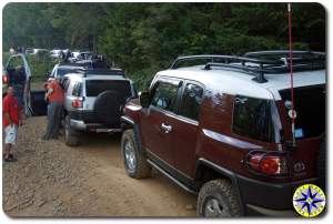 fj cruisers backed up on 4x4 trail