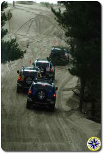 fj cruisers in a row on sand dune trail