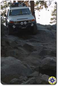 fj cruiser decending steep rock face rubicon trail