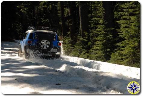 voodoo blue fj cruiser driving through snow 4x4 trail