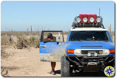 man resting against fj cruiser door mexico