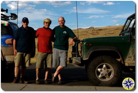 three men in front of trucks