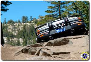 FJ 80 peaking over rock