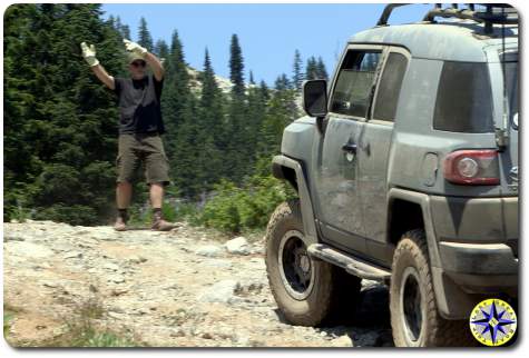 man spotting fj cruiser on trail