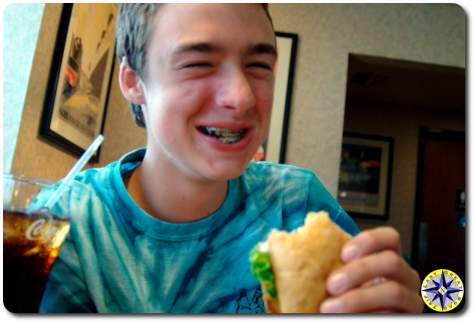 laughing boy eating sandwitch