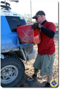 man adding gas from jerry can to fj cruiser