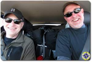 two men smiling in fj cruiser packed with gear