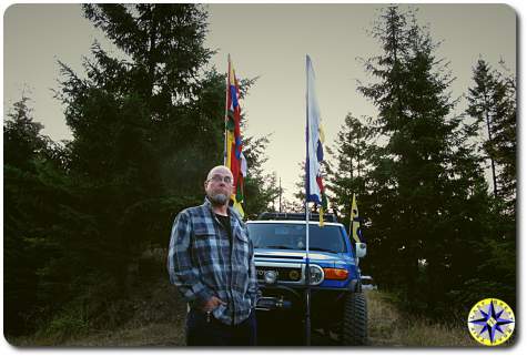 man in front of FJ Cruiser with prayer flags