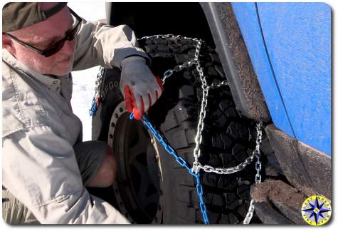 man putting on tire chains